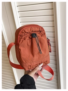 Vue détaillée du sac bandoulière orange en tissu Oxford avec cordon et fermeture éclair