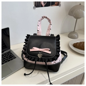 Detail of balletcore backpack with pink bow, lace trim and silver heart pendant