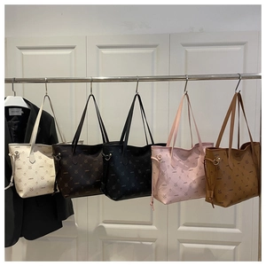 Five assorted colors of vintage monogram tote bags with bear prints hanging on a rack