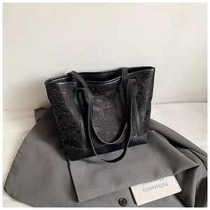 Detail showing butterfly floral print and metal Fashion logo on the black tote bag
