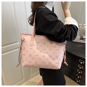 Pink tote bag detail showing textured letter pattern and chic side drawstring design