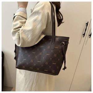 Gros plan du sac cabas marron avec imprimés lapins, motifs monogrammes et cordon de serrage