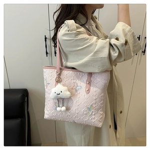 Détail du sac cabas rose clair avec broderie papillon et charm nuage en peluche