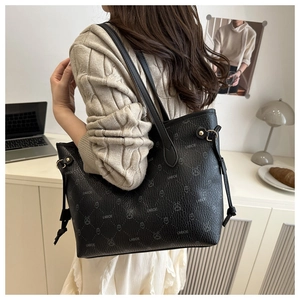 Detail of black tote bag with cute rabbit pattern and stylish side drawstring buckle