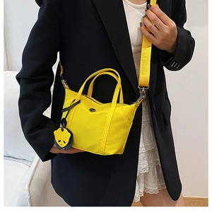 Mini yellow nylon tote bag detail with panda charm and wide adjustable shoulder strap