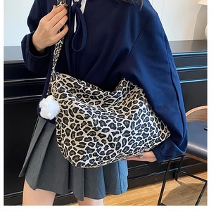 Dettaglio della borsa tote in tela leopardata con ciondolo a pompon bianco soffice