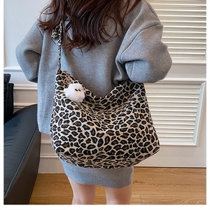 Dettaglio della borsa tote in tela leopardata con ciondolo di peluche e grande capienza
