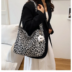 Gros plan du sac cabas en toile léopard avec fermeture éclair et breloque peluche