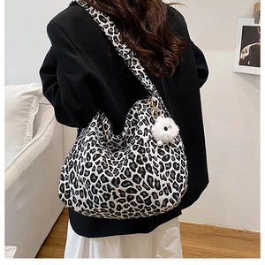 Vue détaillée du grand sac cabas léopard avec breloque en peluche porté par un mannequin