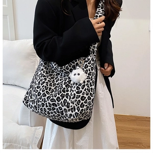 Détail du sac bandoulière léopard avec breloque en peluche et large bandoulière