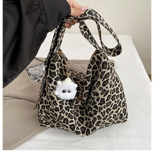 Dettaglio della borsa tote leopardata con tracolla larga e ciondolo di peluche