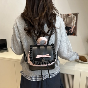 Chic black and pink ballet-core mini backpack with ruffle trim and heart charm on model