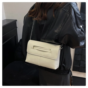 Détail du sac bandoulière crème en cuir PU avec poignée découpée et fine chaîne argentée