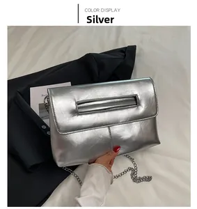 Détail du sac enveloppe argenté métallisé avec poignée rectangulaire et bandoulière chaîne