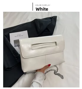 Gros plan d'une pochette blanche en cuir PU minimaliste avec bandoulière chaîne et poignée creuse