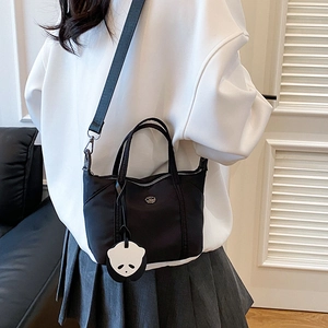 Black nylon mini tote bag with panda pendant and adjustable strap for women