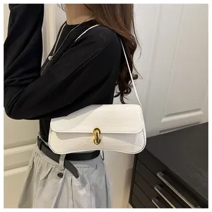 Détail du sac baguette blanc gaufré crocodile avec fermoir doré et fine bandoulière