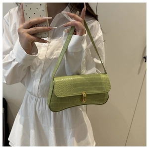 Détail du sac baguette vert clair à motif crocodile avec fermoir en métal doré