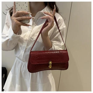 Détail du sac bandoulière rouge foncé effet crocodile avec fermoir rotatif doré