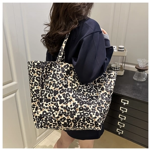 Close-up of leopard print tote bag showing large front snap pocket and sturdy fabric texture