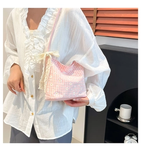 Close-up of pink floral canvas bag featuring daisy prints and a lace bow charm