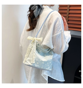 Detailed shot of floral canvas tote featuring white daisy patterns and lace bow accent