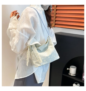 Detailed view of light blue checkered canvas bag with daisy print and white lace ribbon