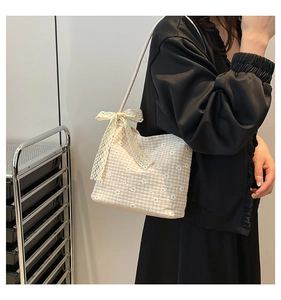 Detail of yellow plaid tote bag featuring daisy prints and a delicate lace bow accent