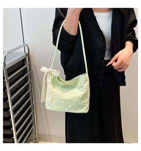 Detail of light green daisy canvas bucket bag with a large white lace bow accessory