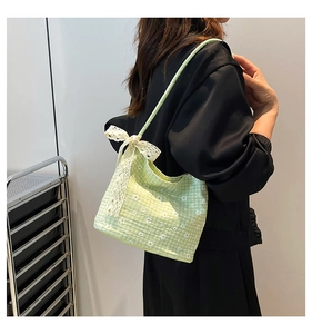 Detail of light green checkerboard canvas bag with daisy prints and white lace bow