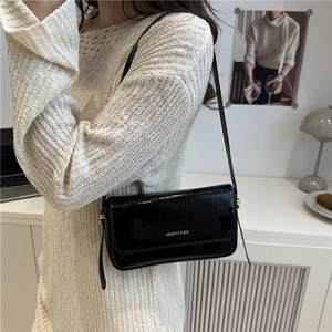 Modern black patent leather shoulder bag with gold logo lettering and long strap