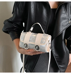 Makroaufnahme einer silbernen Zylindertasche mit Glitzereffekt und Metalldrehverschlüssen