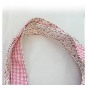 Detailansicht des beidseitigen Schultergurts aus Baumwolle mit Karo- und Blumenmuster