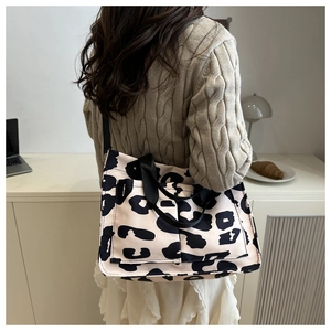 Dettaglio della borsa tote leopardata con tasche multiple e tracolla regolabile donna