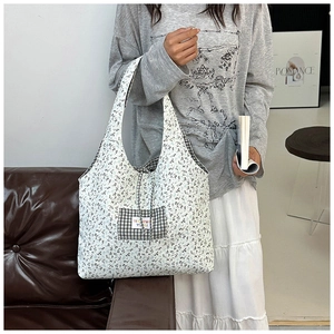 Detail of floral canvas tote bag with check pocket and romance lettering decor