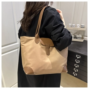 Close-up of a large khaki nylon tote bag with brown leather details for daily commute