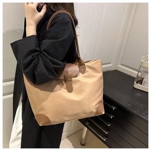 Detail of the nylon tote bag with brown leather handles and magnetic flap closure