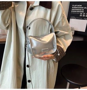 Détail du sac à main en cuir verni argenté avec bandoulière chaîne et poignée