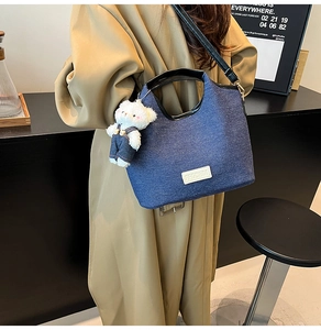 Detailansicht der Denim-Tasche mit süßem Bärenanhänger und weißem Logo-Aufnäher