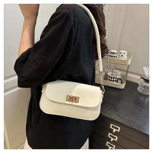 Detail of white leather shoulder bag featuring a stylish golden metal lock and strap