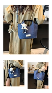 Detail der blauen Denim-Tasche mit Plüschbären-Anhänger und Lederriemen für Damen