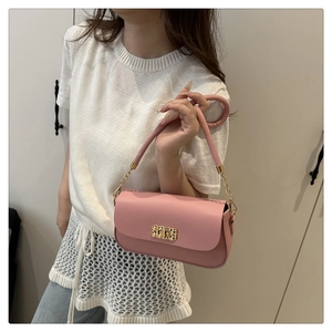 Vue latérale du sac sous le bras en cuir rose avec boucle dorée sur un mannequin