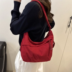Red corduroy hobo crescent bag for women with woven zipper pull detail and casual style