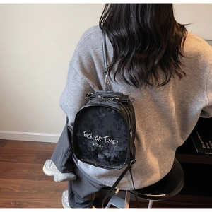 Detail of Trick or Treat black velvet backpack with white handwritten lettering