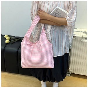 Detail of pink plaid canvas tote bag featuring floral lining and drawstring bow knot