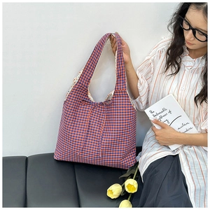 Detail of red and blue checkered canvas tote bag featuring a decorative drawstring bow