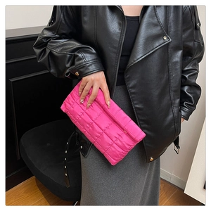 Close-up of bright pink quilted puffer clutch bag with cross-stitched puffy texture