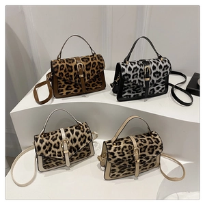 Leopard print crossbody bags with metal buckle detail on minimalist white display