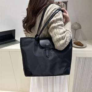 Large black nylon tote bag with leather trim for women commuting or casual travel use