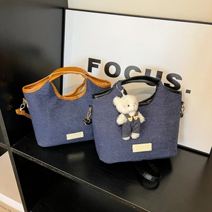 Große Denim-Canvas-Tragetaschen mit Ledergriffen und Bärenanhänger im herbstlichen Stil